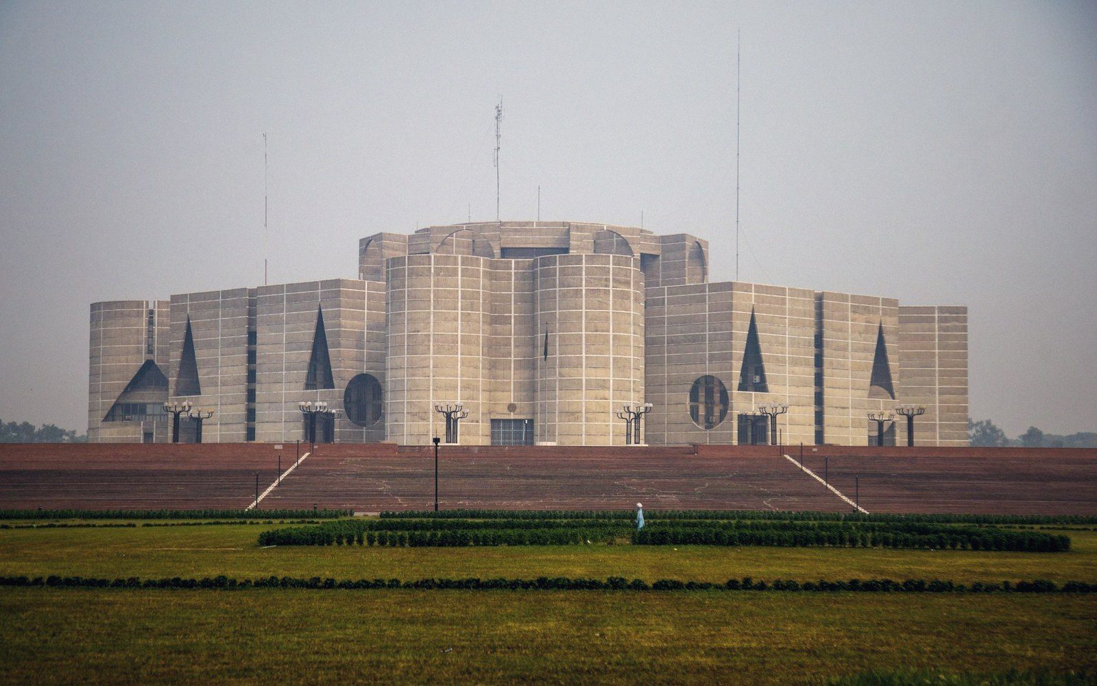 Exterior of a grey concrete government building under an overcast sky